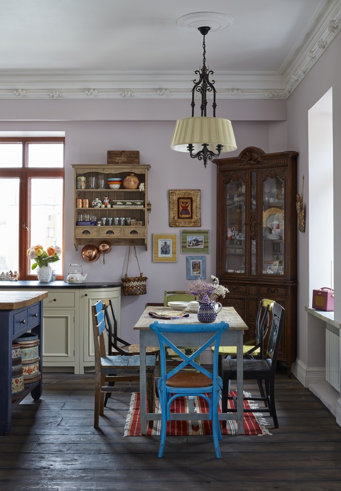 This is an example of an eclectic dining room in Moscow with pink walls and dark hardwood flooring.
