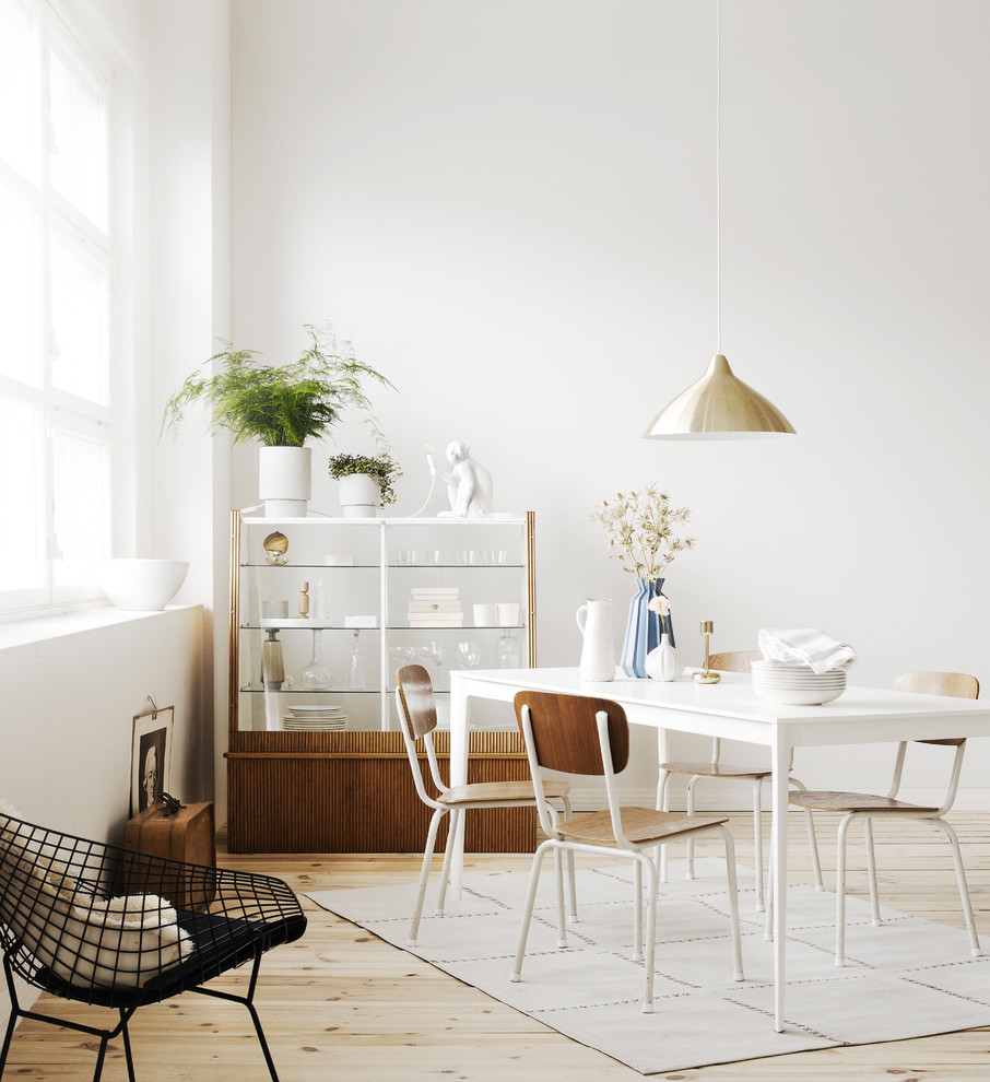 Immagine di una sala da pranzo scandinava con pareti bianche, pavimento beige e pavimento in compensato
