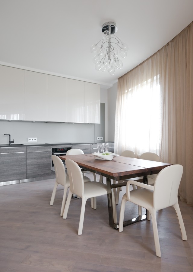 Immagine di una sala da pranzo aperta verso la cucina minimal di medie dimensioni con pareti grigie, parquet chiaro, pavimento marrone e nessun camino