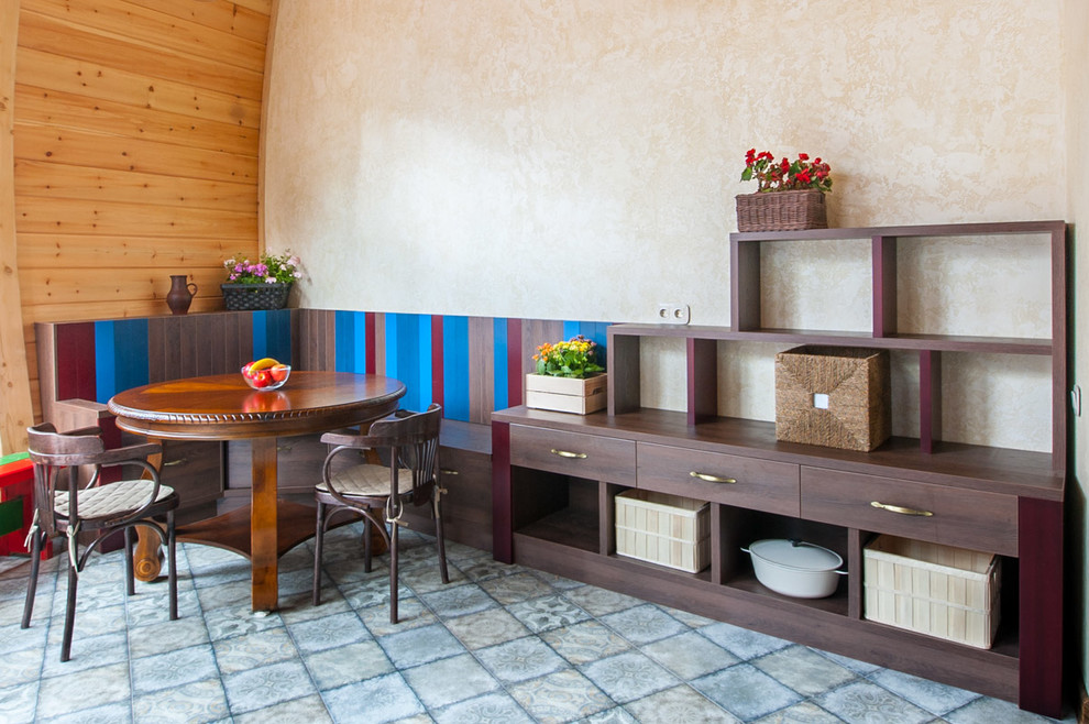 Cette photo montre une salle à manger ouverte sur la cuisine tendance avec un mur multicolore, sol en béton ciré et un sol gris.