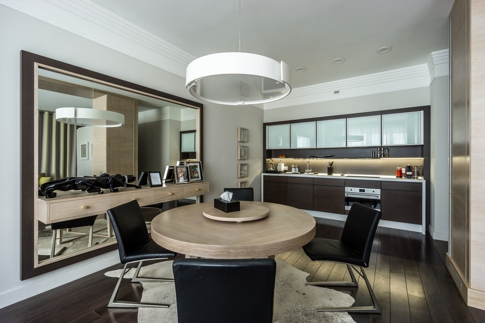 Стильный дизайн: кухня-столовая в современном стиле с серыми стенами, темным паркетным полом и коричневым полом - последний тренд