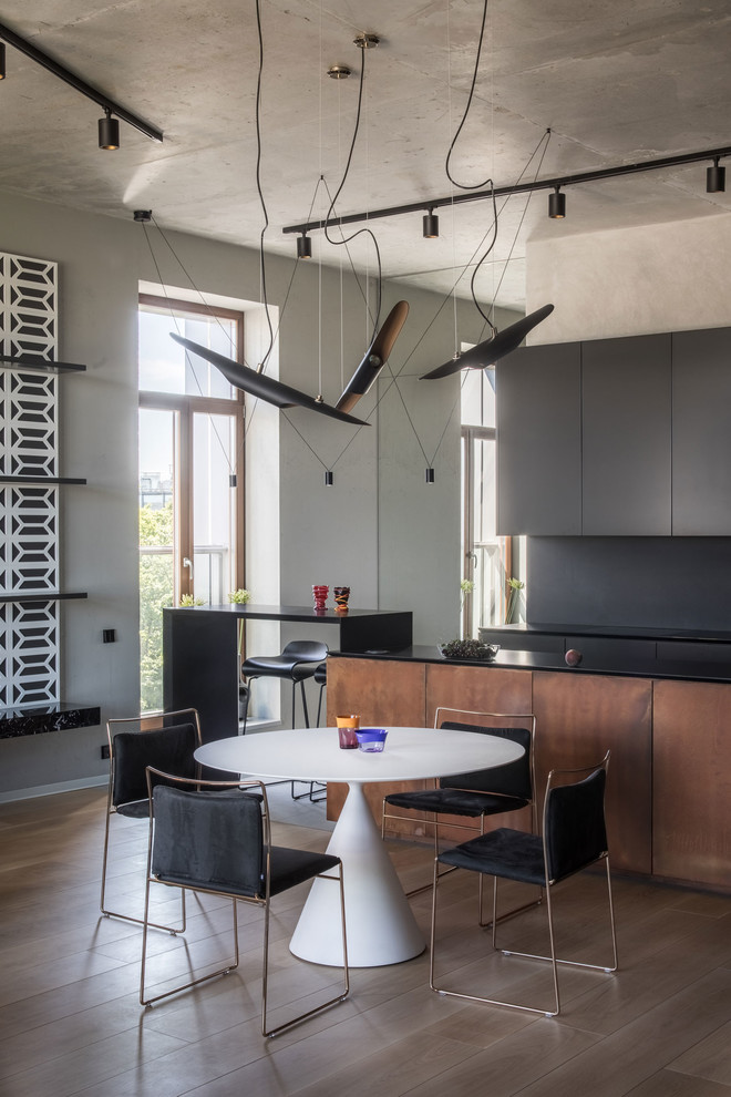 Idee per una sala da pranzo aperta verso la cucina industriale con pareti grigie, pavimento in legno massello medio e pavimento marrone
