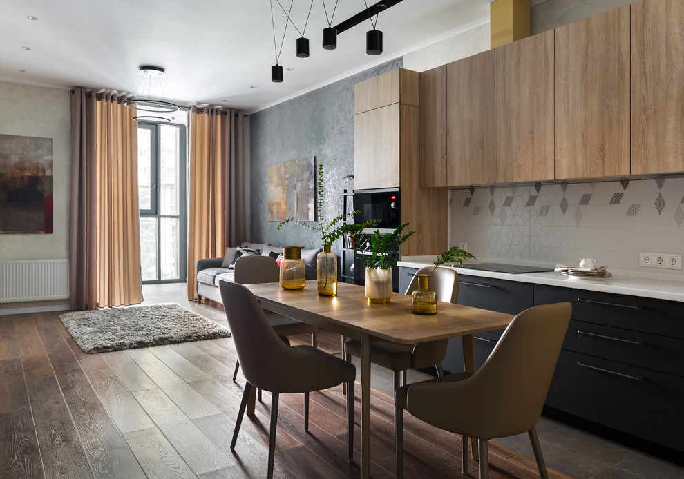 Immagine di una sala da pranzo aperta verso la cucina design di medie dimensioni con pavimento in laminato e pavimento marrone