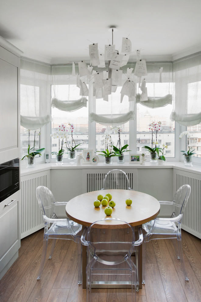Kitchen/dining room combo - mid-sized contemporary medium tone wood floor kitchen/dining room combo idea in Moscow with white walls