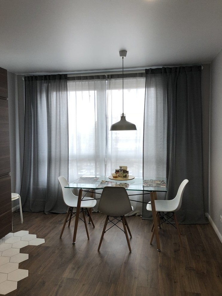 Foto på ett mellanstort minimalistiskt kök med matplats, med grå väggar, laminatgolv och brunt golv