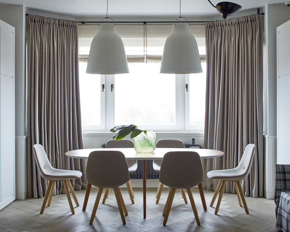 Exemple d'une salle à manger ouverte sur le salon scandinave de taille moyenne avec un mur blanc, parquet clair et un sol beige.