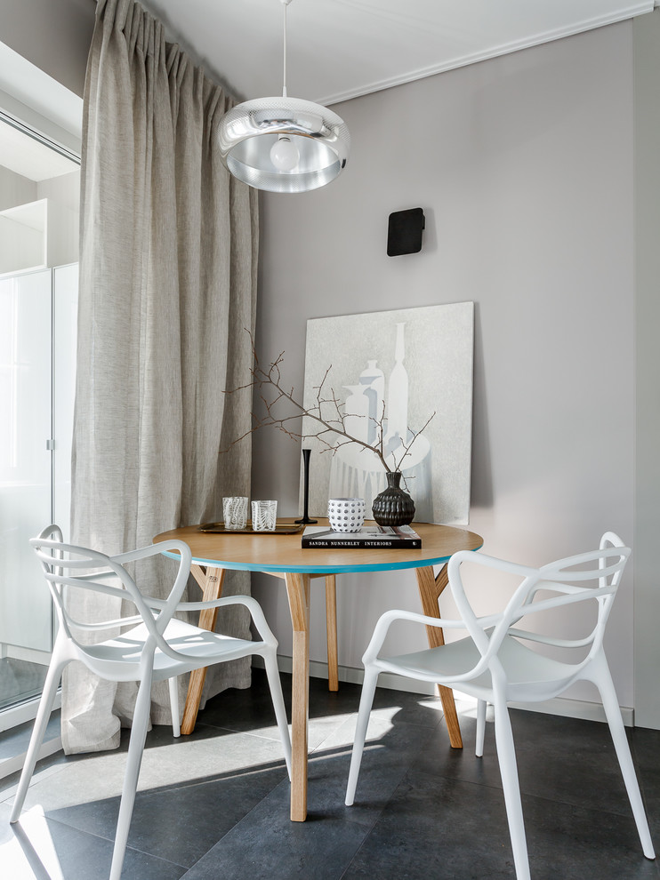 Cette image montre une salle à manger ouverte sur la cuisine design avec un mur gris et un sol noir.