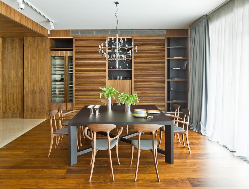 На фото: гостиная-столовая в современном стиле с паркетным полом среднего тона, коричневым полом и коричневыми стенами без камина