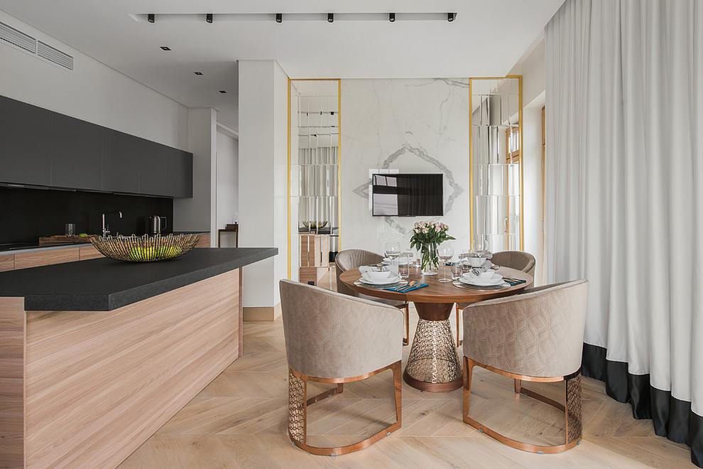 Réalisation d'une salle à manger ouverte sur la cuisine design avec parquet clair, un sol beige et un mur blanc.