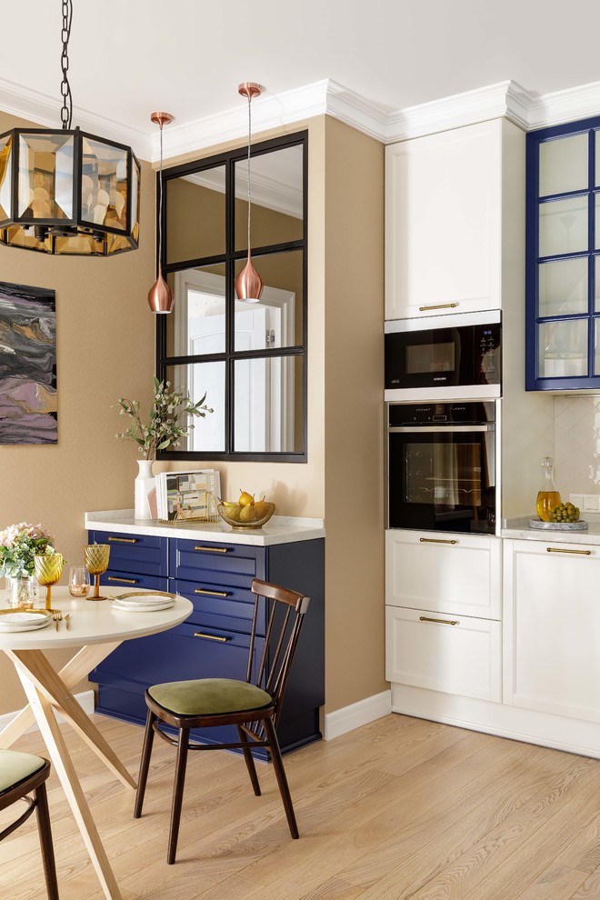 Esempio di una sala da pranzo aperta verso la cucina chic di medie dimensioni con pavimento beige, pareti beige e parquet chiaro