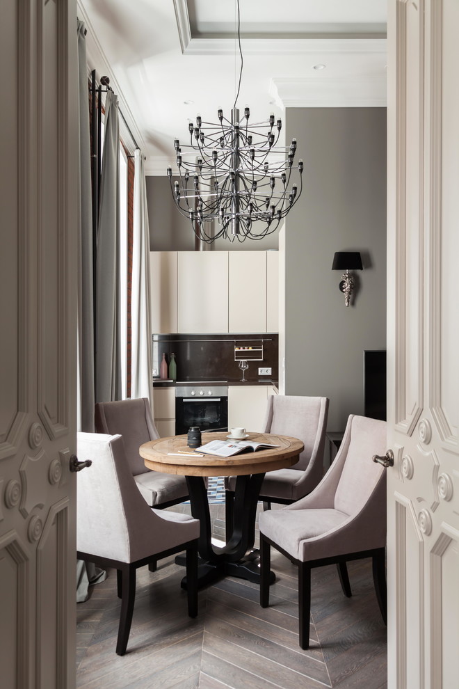 Imagen de comedor clásico renovado de tamaño medio abierto con paredes grises, suelo gris y suelo de madera en tonos medios
