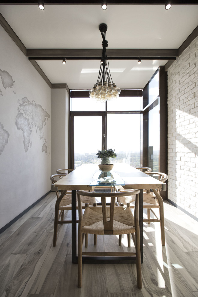 Cette image montre une salle à manger ouverte sur la cuisine design avec un sol en bois brun, un sol gris et un mur blanc.