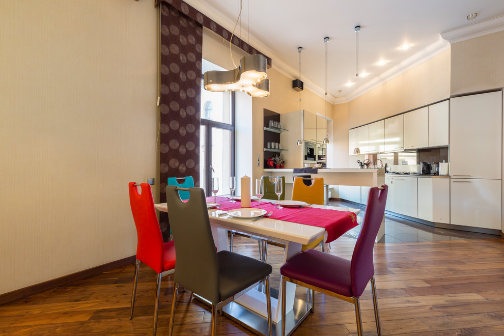 Cette photo montre une salle à manger ouverte sur la cuisine tendance avec un mur beige, parquet foncé et un sol marron.