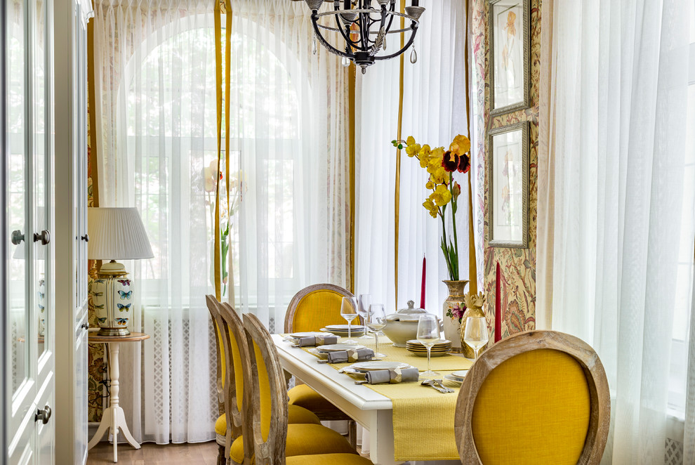 Diseño de comedor clásico renovado pequeño cerrado con paredes amarillas, suelo de madera en tonos medios y suelo beige