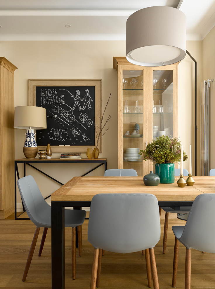 На фото: кухня-столовая в современном стиле с бежевыми стенами и паркетным полом среднего тона с
