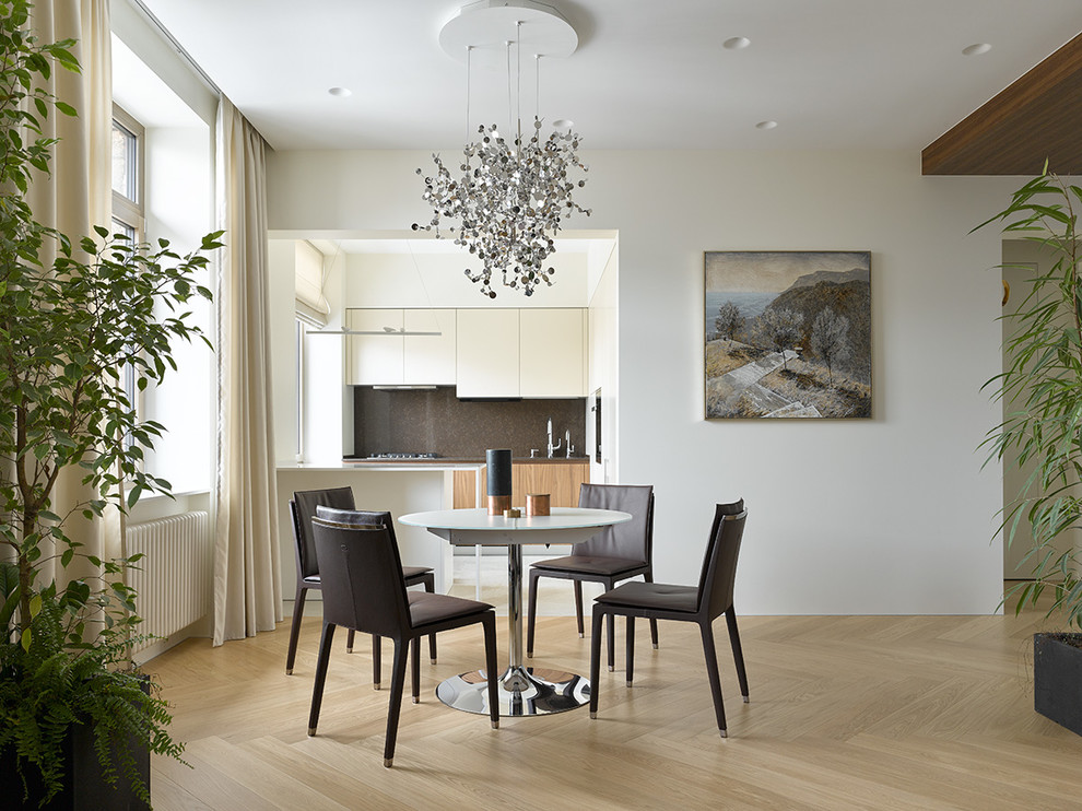 Foto di una sala da pranzo aperta verso il soggiorno minimal con pareti bianche, parquet chiaro e pavimento beige