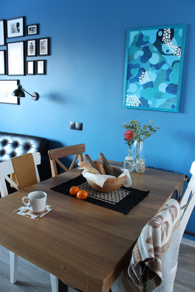 На фото: гостиная-столовая среднего размера в стиле лофт с синими стенами, полом из ламината и серым полом без камина с