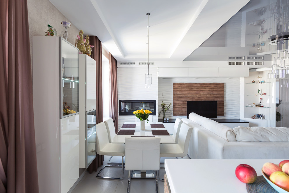 Immagine di una sala da pranzo aperta verso il soggiorno minimal con pareti bianche, camino lineare Ribbon e pavimento grigio