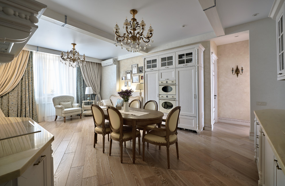 Modelo de comedor clásico de tamaño medio abierto con paredes beige, suelo de madera en tonos medios y suelo beige