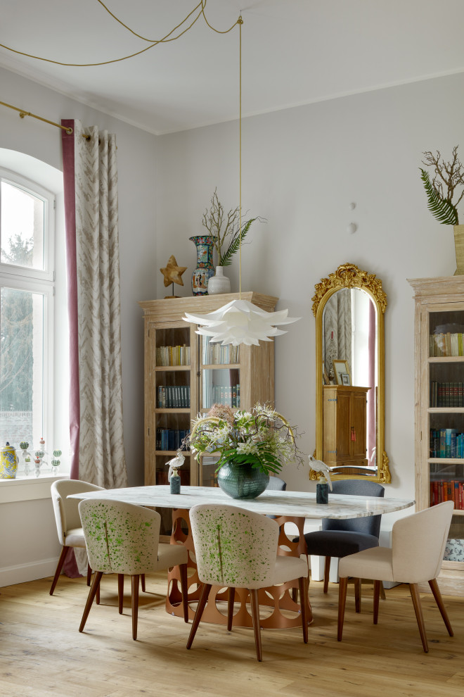 Stilmix Esszimmer mit braunem Holzboden, braunem Boden und grauer Wandfarbe in Sonstige