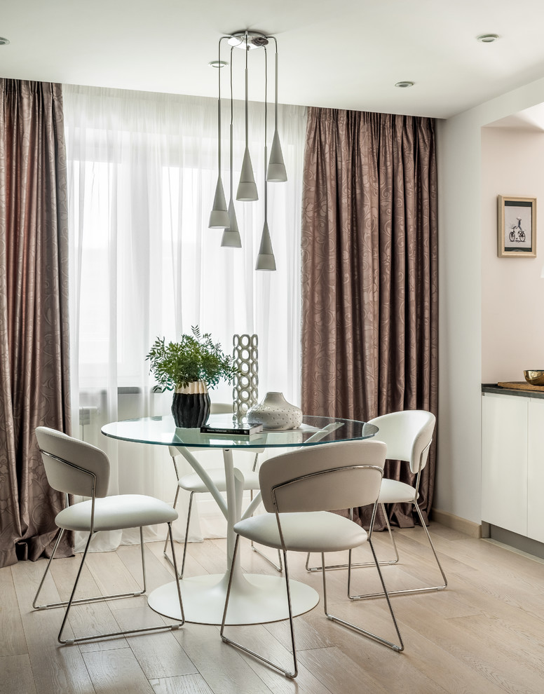 Contemporary dining room in Moscow with white walls and beige floors.