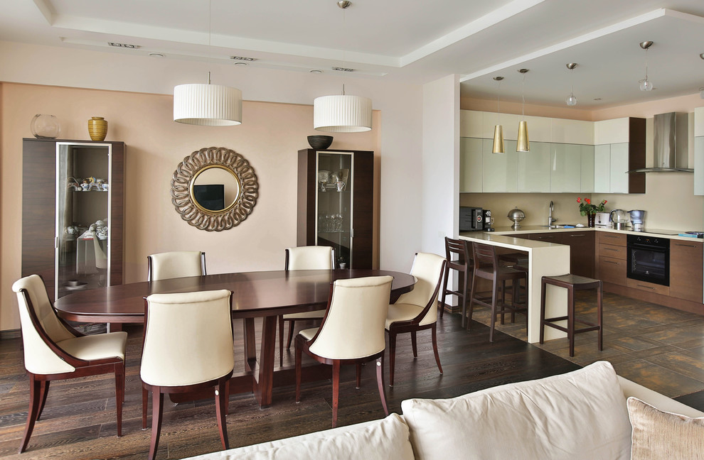 Immagine di una sala da pranzo aperta verso il soggiorno tradizionale con parquet scuro e soffitto ribassato