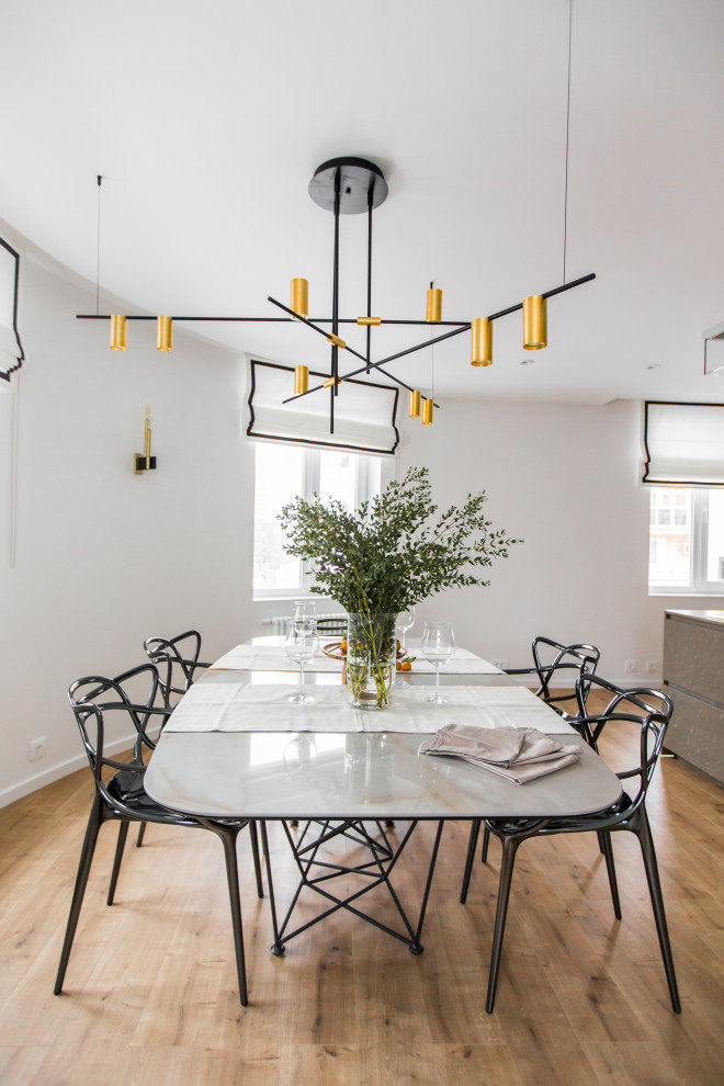 Aménagement d'une salle à manger ouverte sur le salon contemporaine avec un mur blanc, un sol en bois brun et un sol marron.