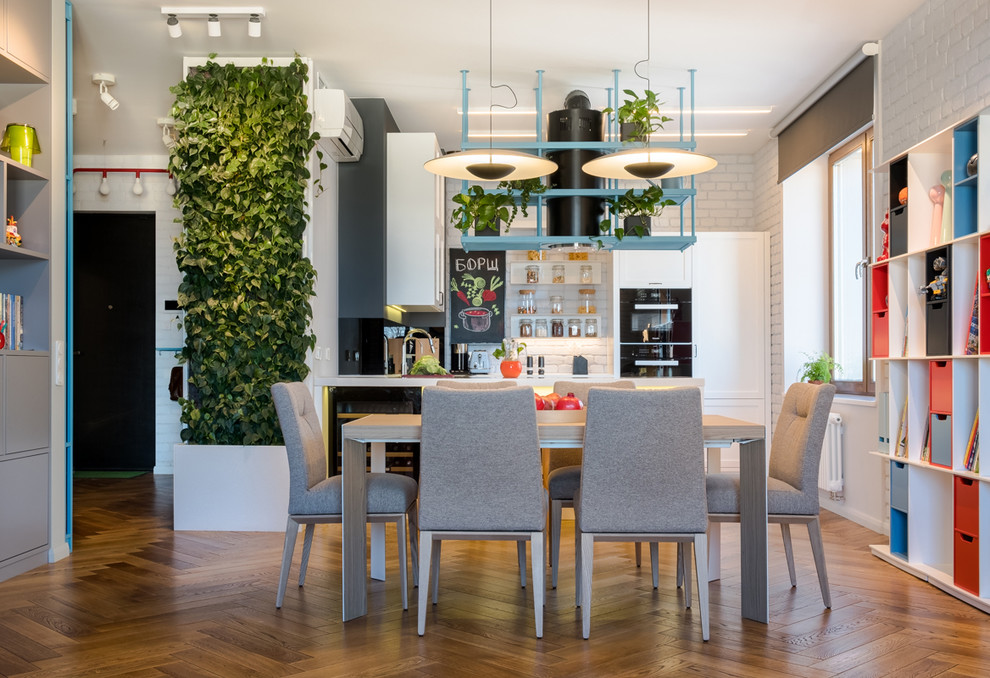 Réalisation d'une salle à manger ouverte sur la cuisine urbaine de taille moyenne avec un mur blanc, un sol en bois brun et un sol marron.