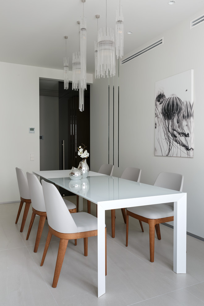 Foto di una sala da pranzo aperta verso la cucina minimal con pareti bianche, pavimento in gres porcellanato e pavimento grigio