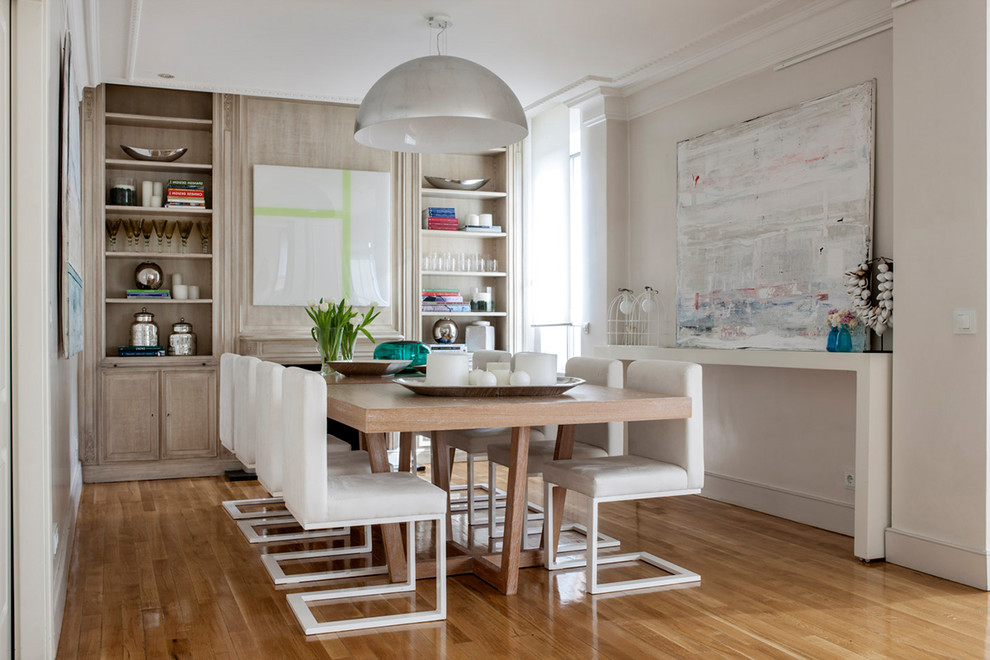 Imagen de comedor clásico renovado abierto con paredes blancas y suelo de madera en tonos medios