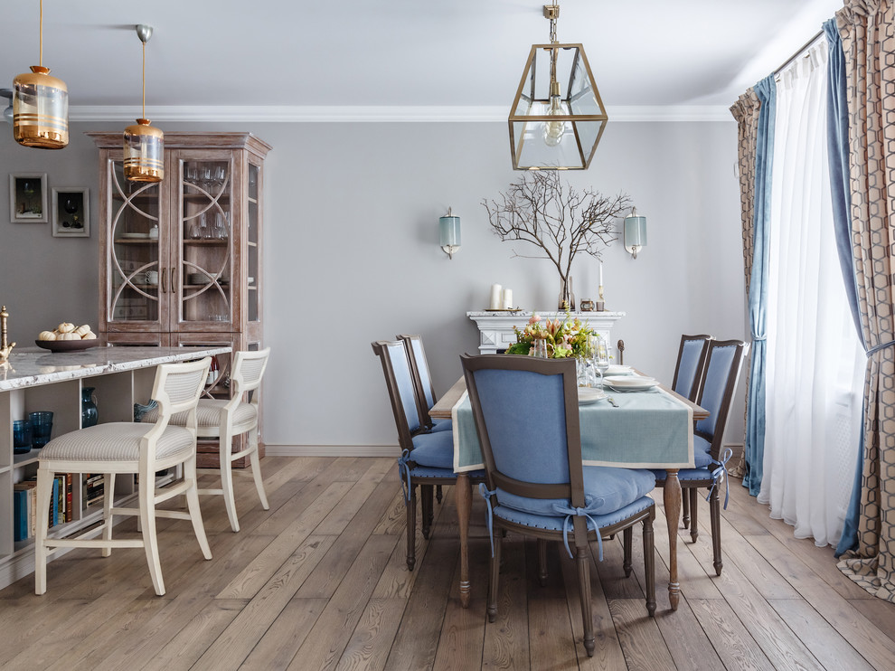 Idee per una sala da pranzo aperta verso la cucina chic con pareti grigie, pavimento in legno massello medio e pavimento marrone