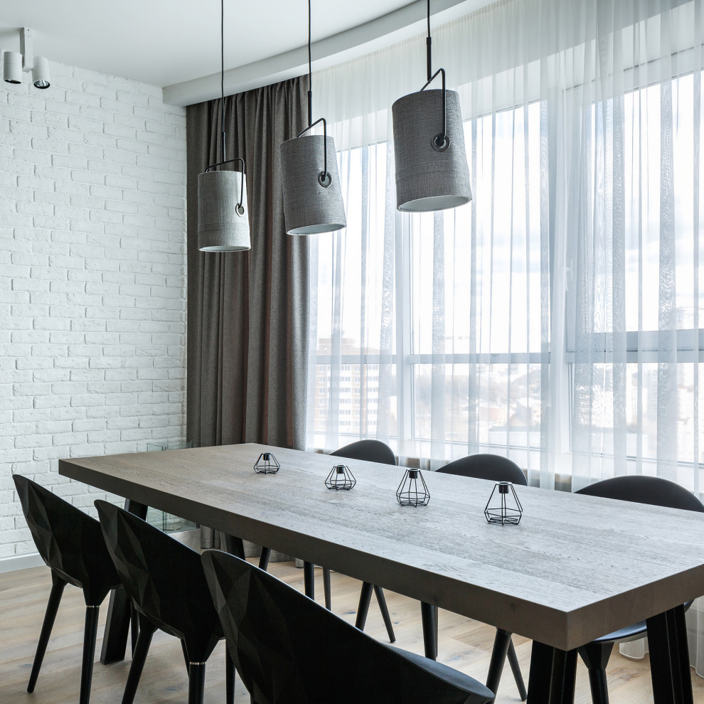 Immagine di una sala da pranzo industriale di medie dimensioni con pareti bianche, pavimento in legno massello medio, pavimento beige e pareti in mattoni