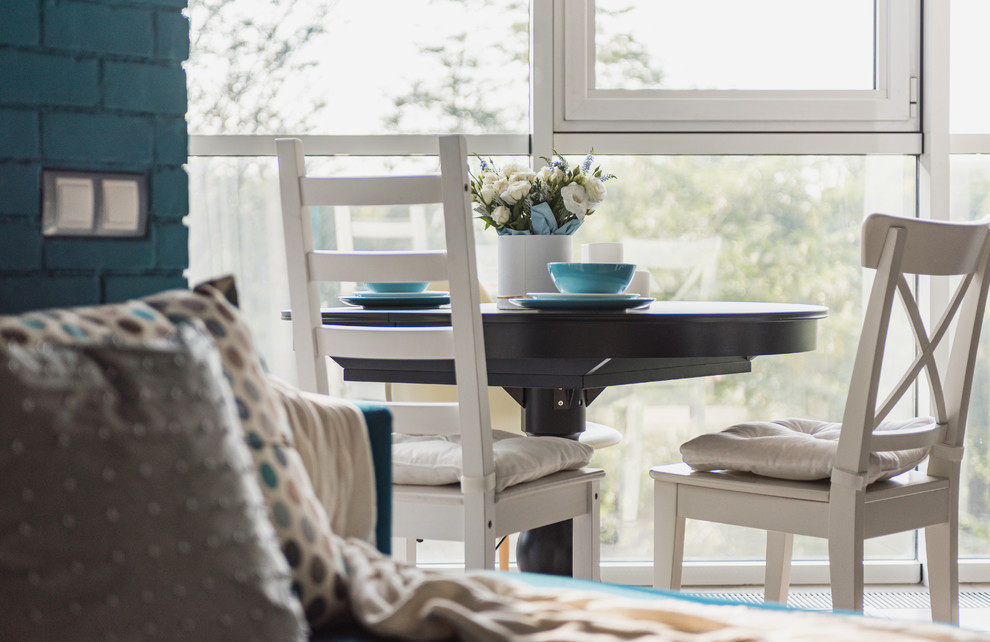 На фото: маленькая гостиная-столовая в стиле фьюжн с полом из ламината и серым полом для на участке и в саду с