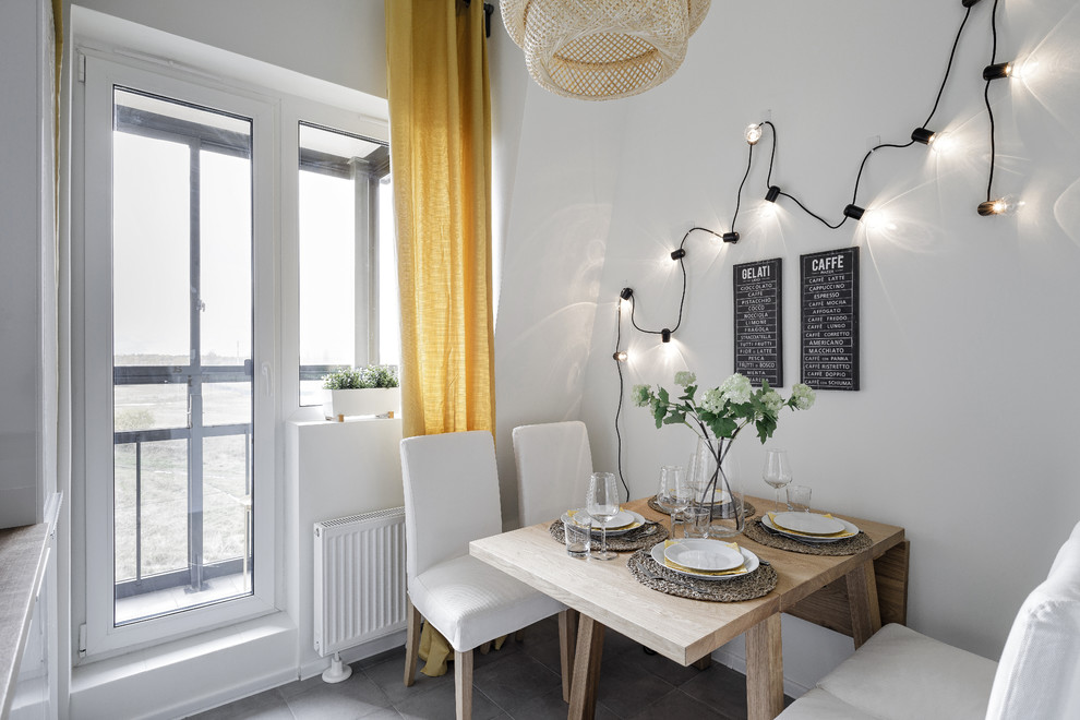 Idée de décoration pour une salle à manger ouverte sur la cuisine nordique avec un mur blanc, un sol gris, un sol en carrelage de porcelaine et éclairage.