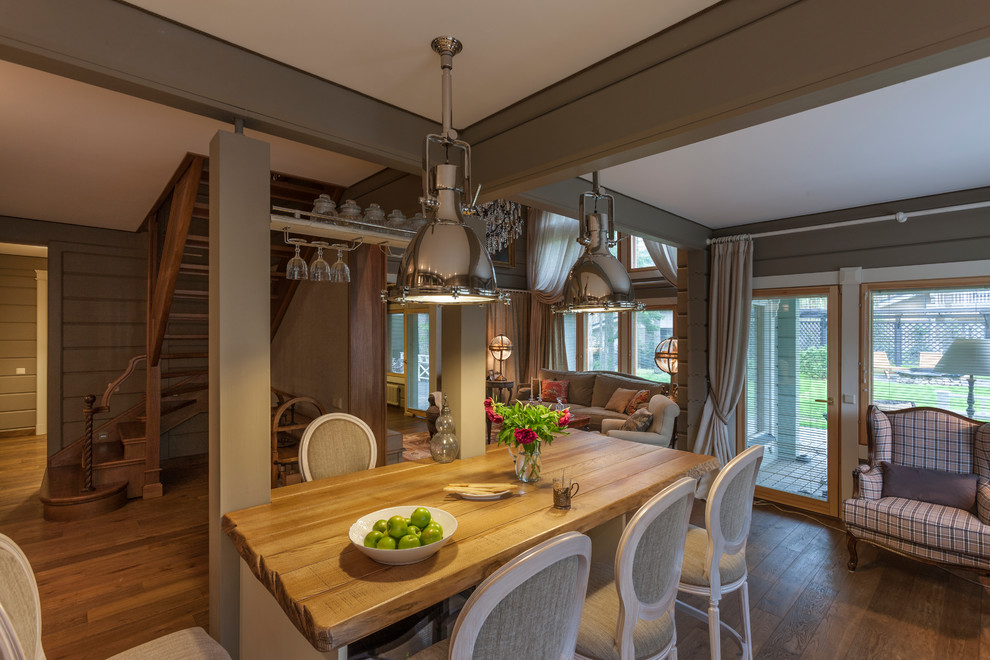 Ispirazione per una sala da pranzo aperta verso la cucina tradizionale con pareti grigie, pavimento in legno massello medio e pavimento marrone