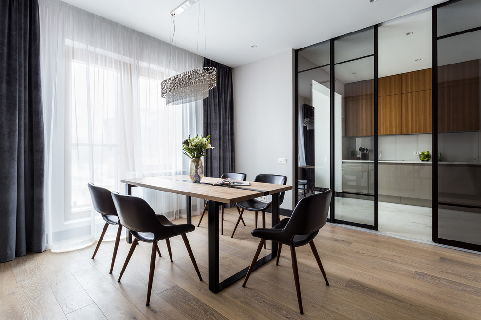 This is an example of a contemporary enclosed dining room in Saint Petersburg with medium hardwood flooring, brown floors and white walls.
