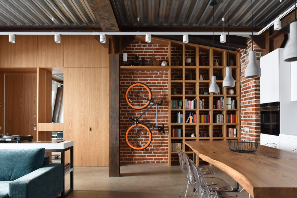 Idee per una sala da pranzo aperta verso il soggiorno industriale di medie dimensioni con pareti rosse, pavimento in cemento e pavimento grigio