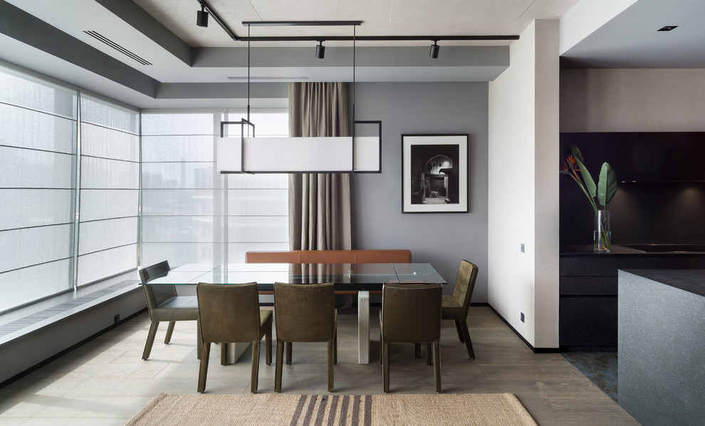 Réalisation d'une salle à manger ouverte sur le salon design de taille moyenne avec un mur gris, un sol en bois brun et un sol marron.