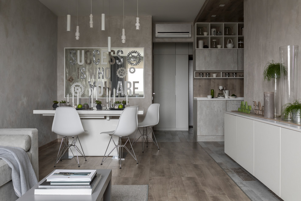 Immagine di una sala da pranzo aperta verso il soggiorno minimal con pareti grigie, pavimento in legno massello medio e pavimento marrone
