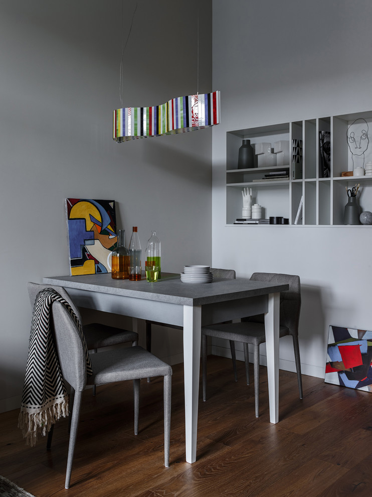 Стильный дизайн: столовая в современном стиле с серыми стенами, темным паркетным полом и коричневым полом - последний тренд
