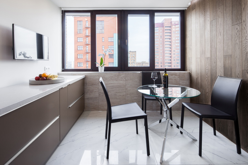 Foto di una sala da pranzo aperta verso la cucina minimal con pavimento bianco