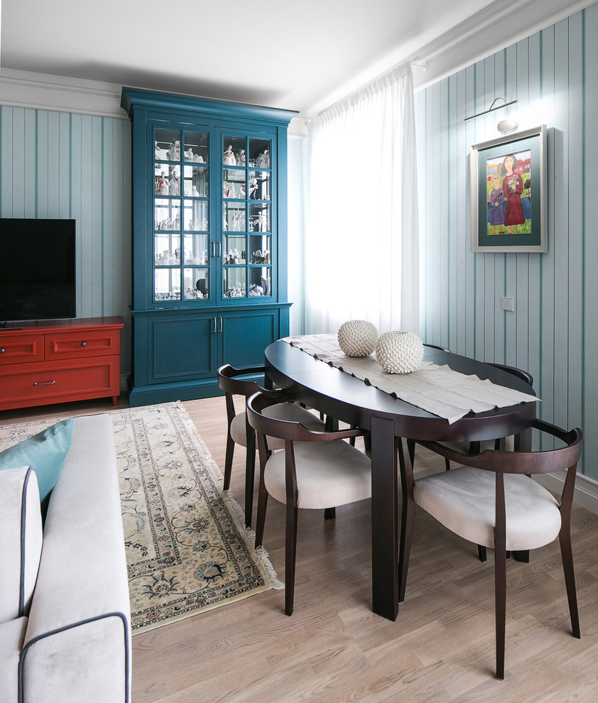 Ejemplo de comedor bohemio con paredes azules y suelo de madera clara