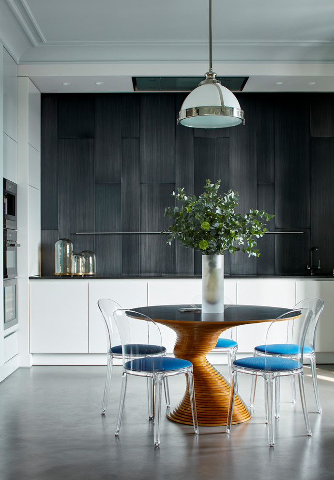 Idee per una sala da pranzo minimal con pavimento grigio, pareti nere e pavimento in cemento