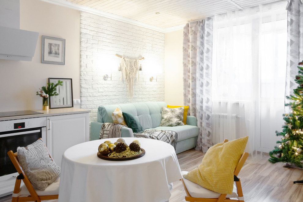 Стильный дизайн: маленькая гостиная-столовая в скандинавском стиле с бежевыми стенами, полом из ламината и коричневым полом без камина для на участке и в саду - последний тренд