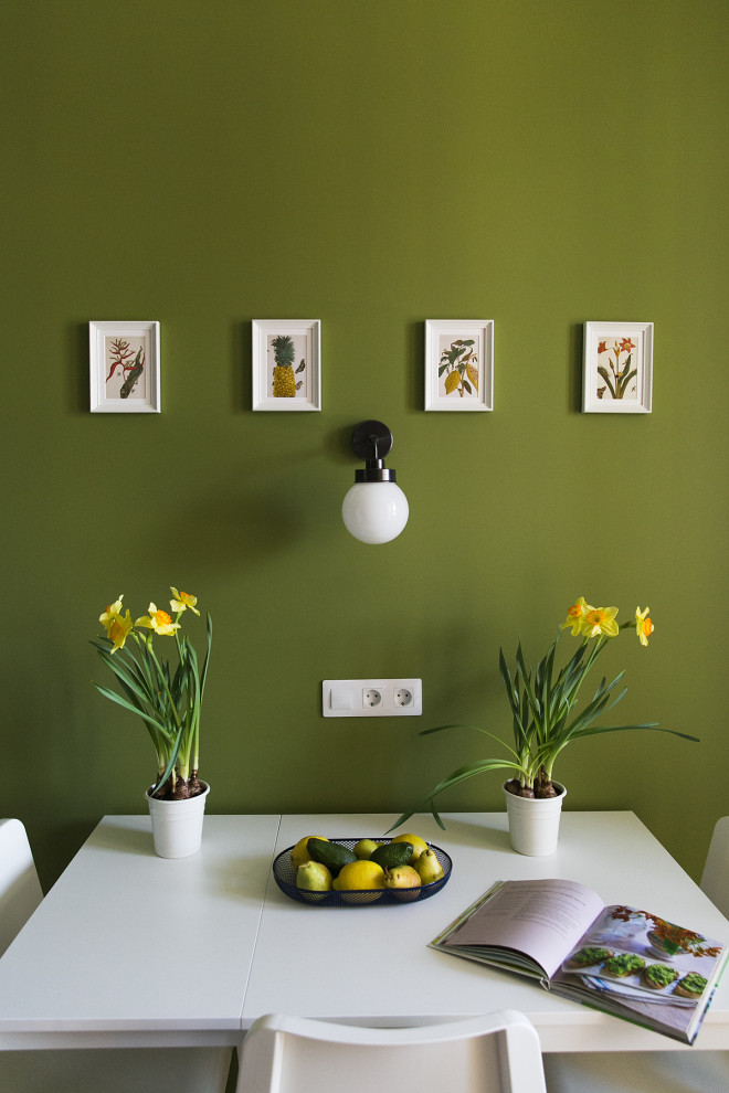 Exemple d'une salle à manger ouverte sur la cuisine scandinave de taille moyenne avec un mur vert, sol en stratifié et un sol marron.