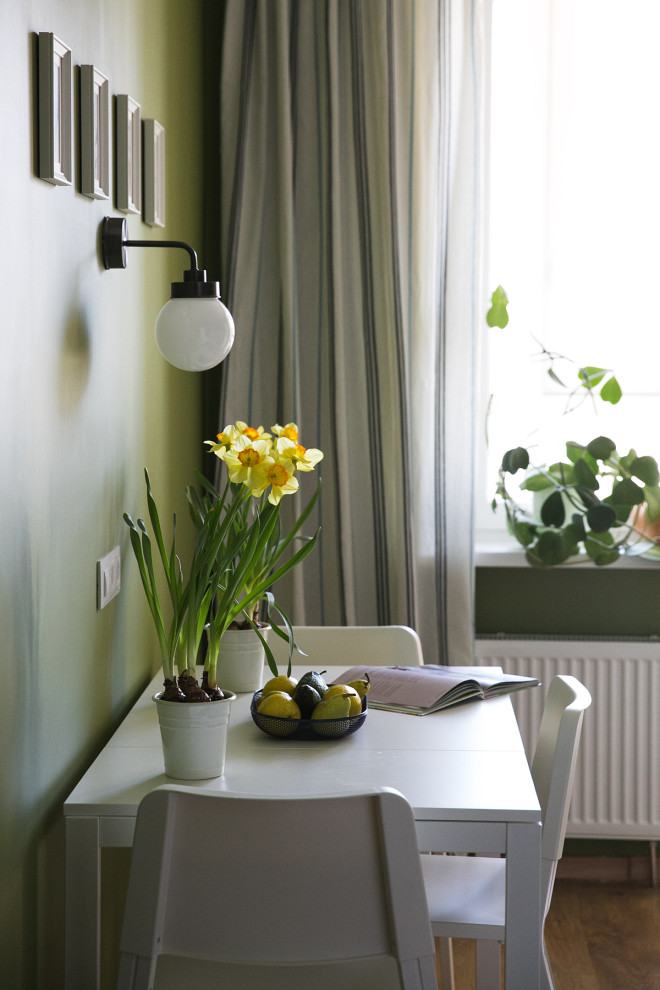 На фото: кухня-столовая среднего размера в скандинавском стиле с зелеными стенами, полом из ламината и коричневым полом с