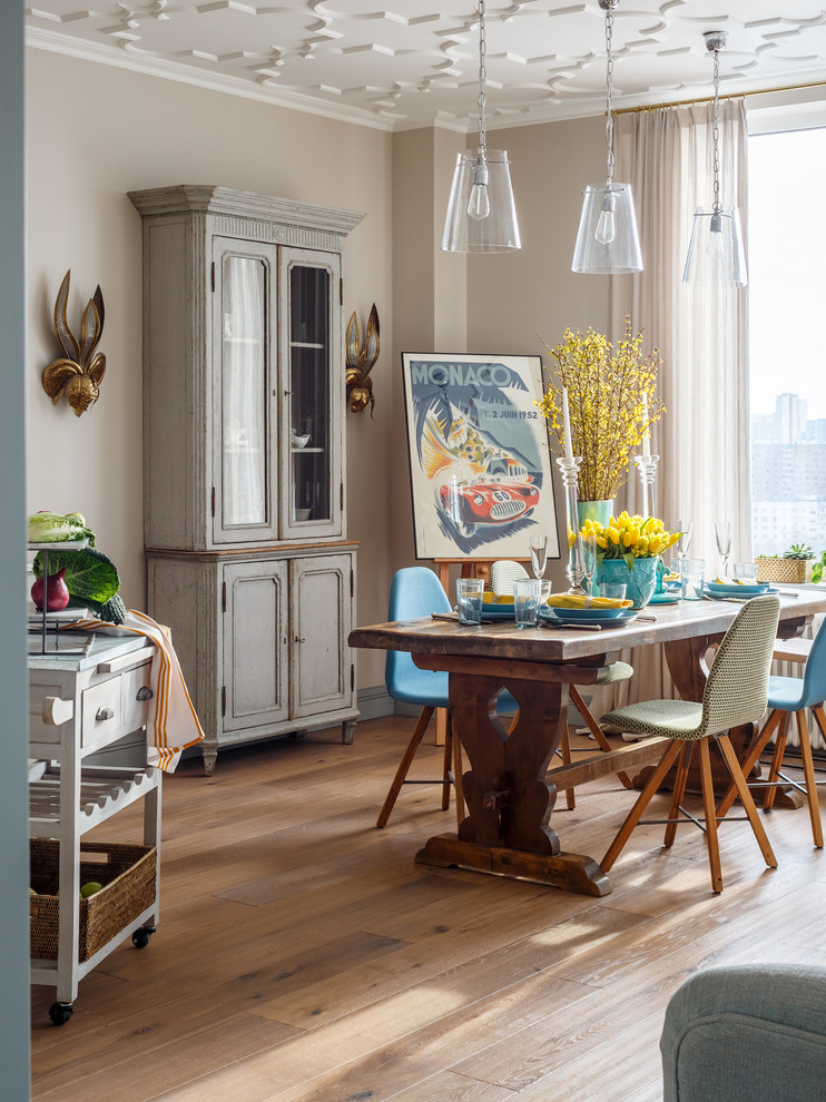 Bohemian open plan dining room in Moscow with beige walls, light hardwood flooring and beige floors.