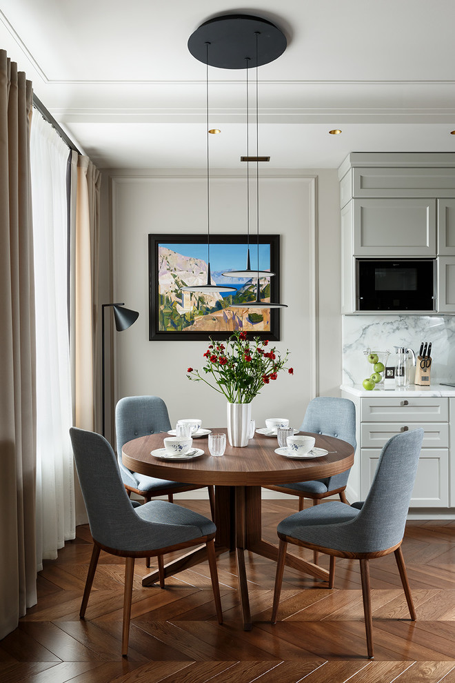 Cette image montre une salle à manger traditionnelle avec un mur beige, parquet foncé, un sol marron et éclairage.