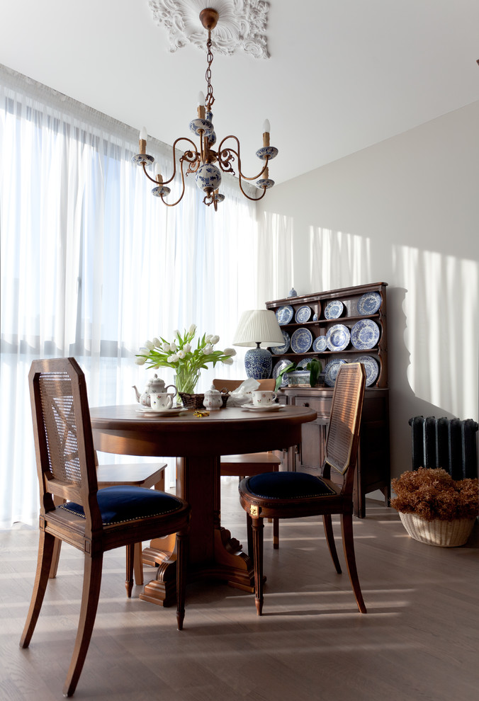 Foto di una sala da pranzo aperta verso il soggiorno chic con pareti beige e parquet chiaro