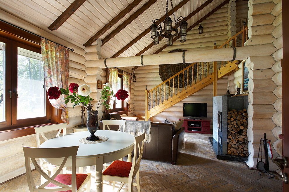 Esempio di una sala da pranzo aperta verso il soggiorno country con stufa a legna